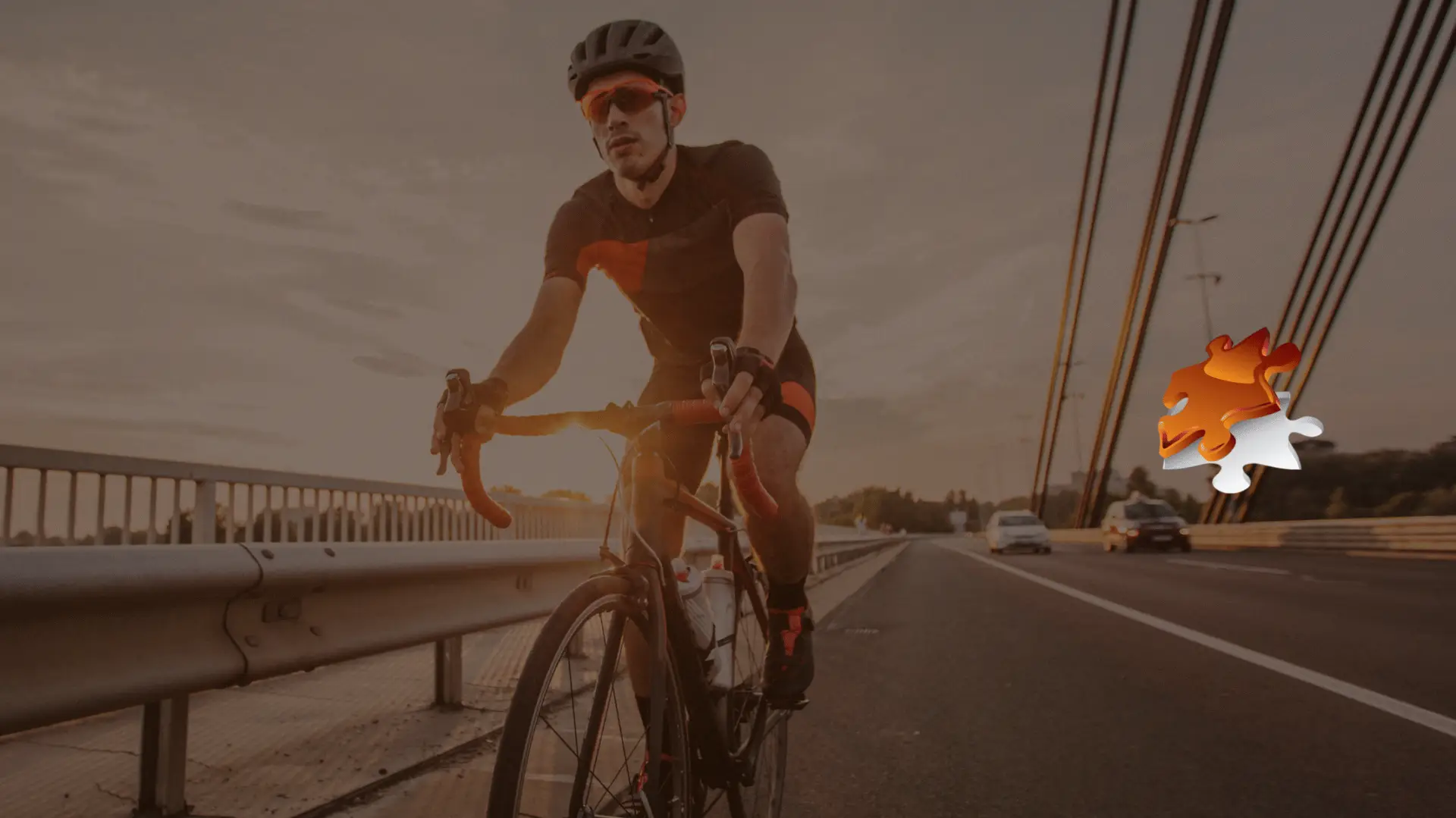Cyclist riding on the side of a bridge at sunset with cars approaching in the background, symbolizing the dangers of sharing the road.