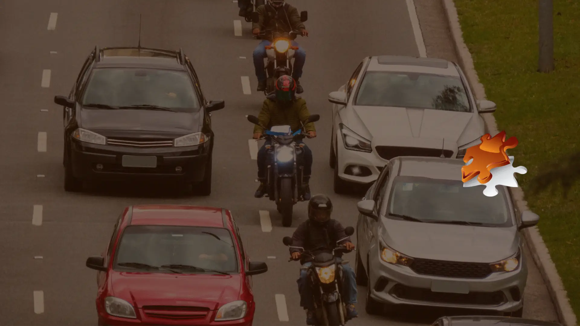 Motorcyclist riding between lanes on a California highway, illustrating legal lane splitting.